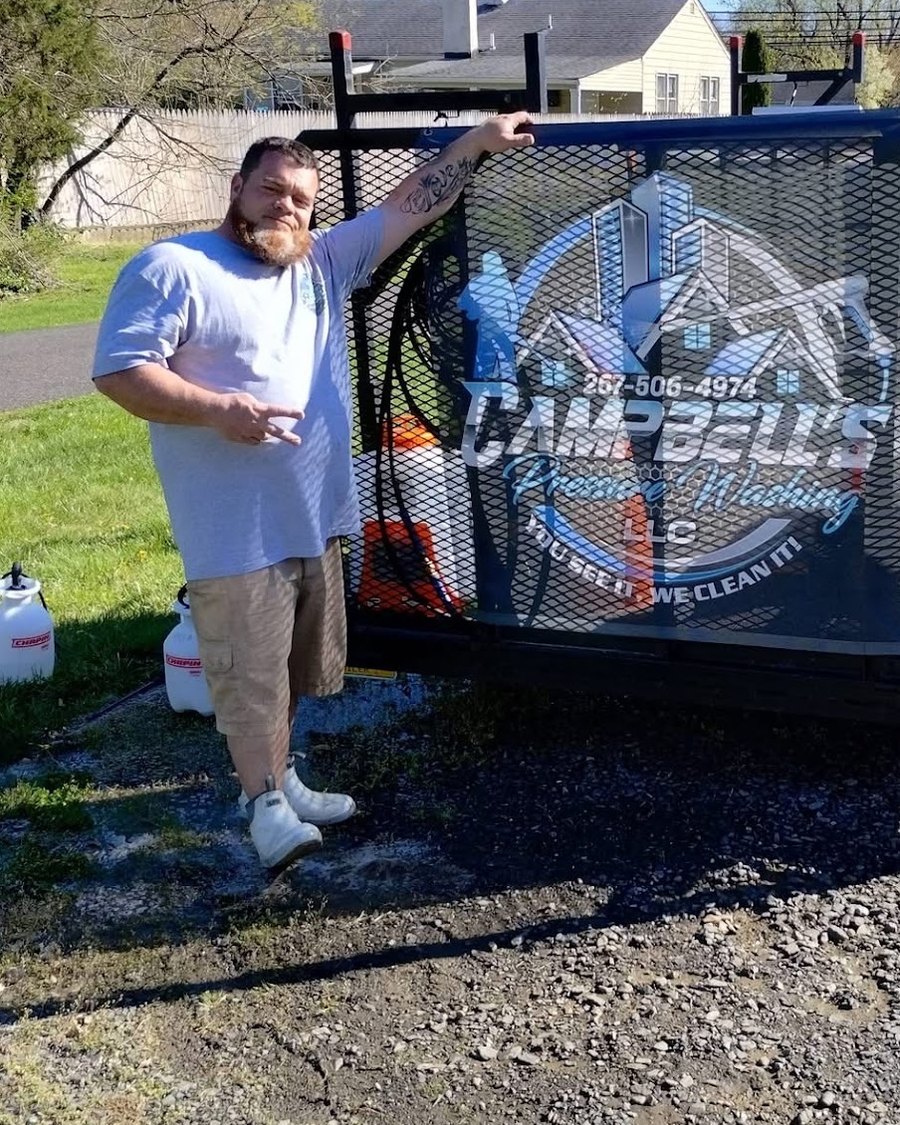 Josh Campbell, owner of Campbell's Pressure Washing LLC, beside his branded equipment trailer